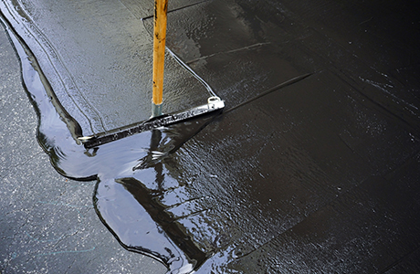 Freshly paved commercial parking lot with clear white line striping in front of a business building
